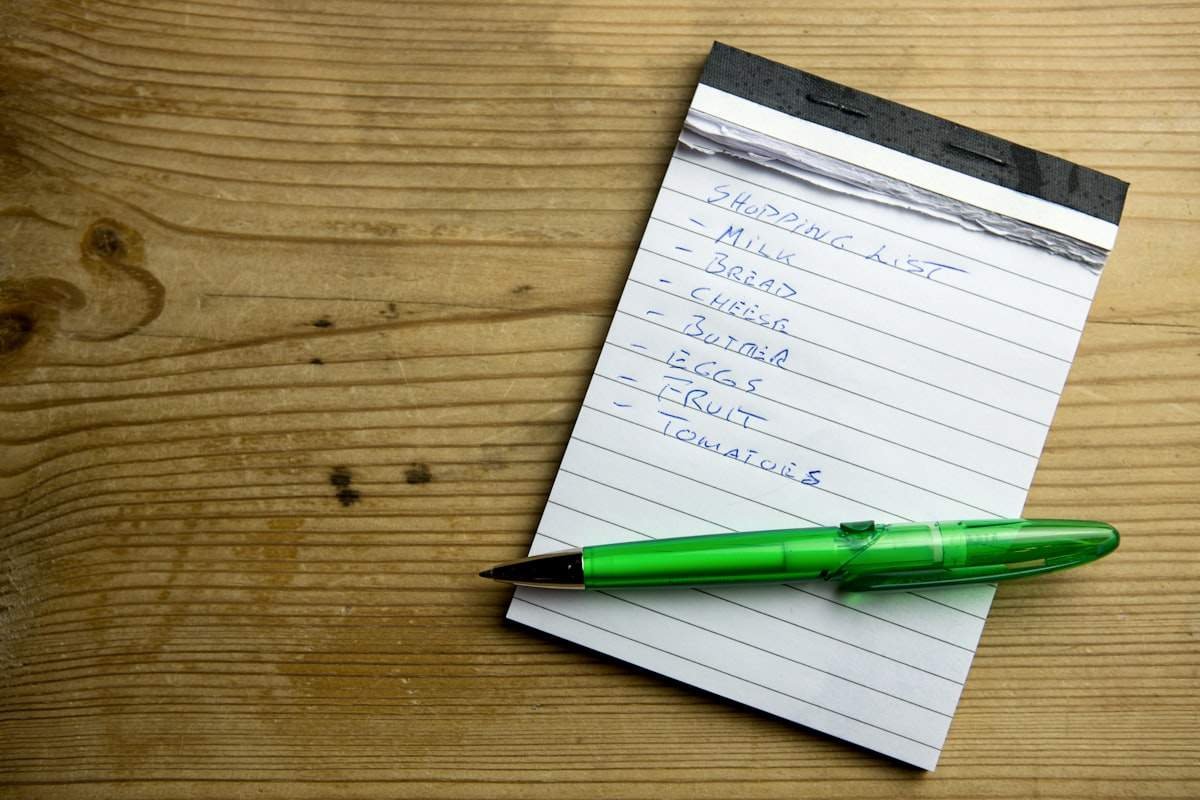 Do you need a comma before and illustrated by a handwritten shopping list on a notepad with a green pen