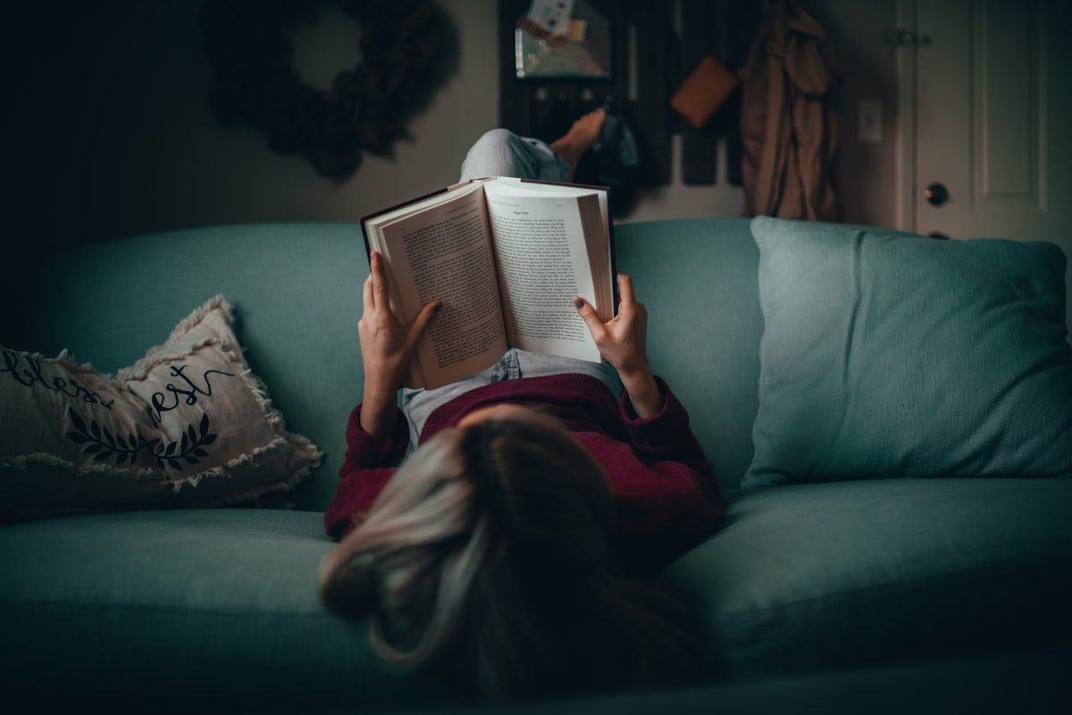 How to memorize poems illustrated by a reader absorbed in a poetry book on a couch