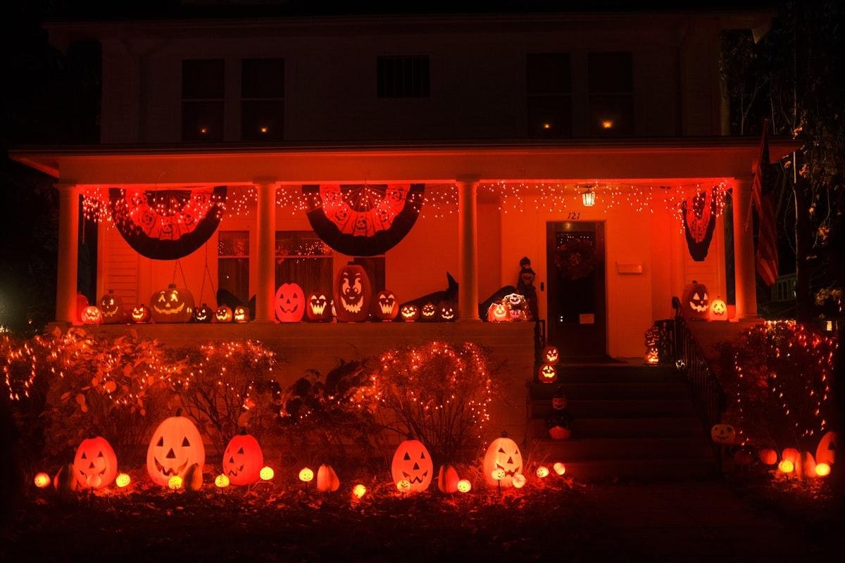 Idioms for Halloween evoked by a porch glowing with dozens of carved jack-o-lanterns at night