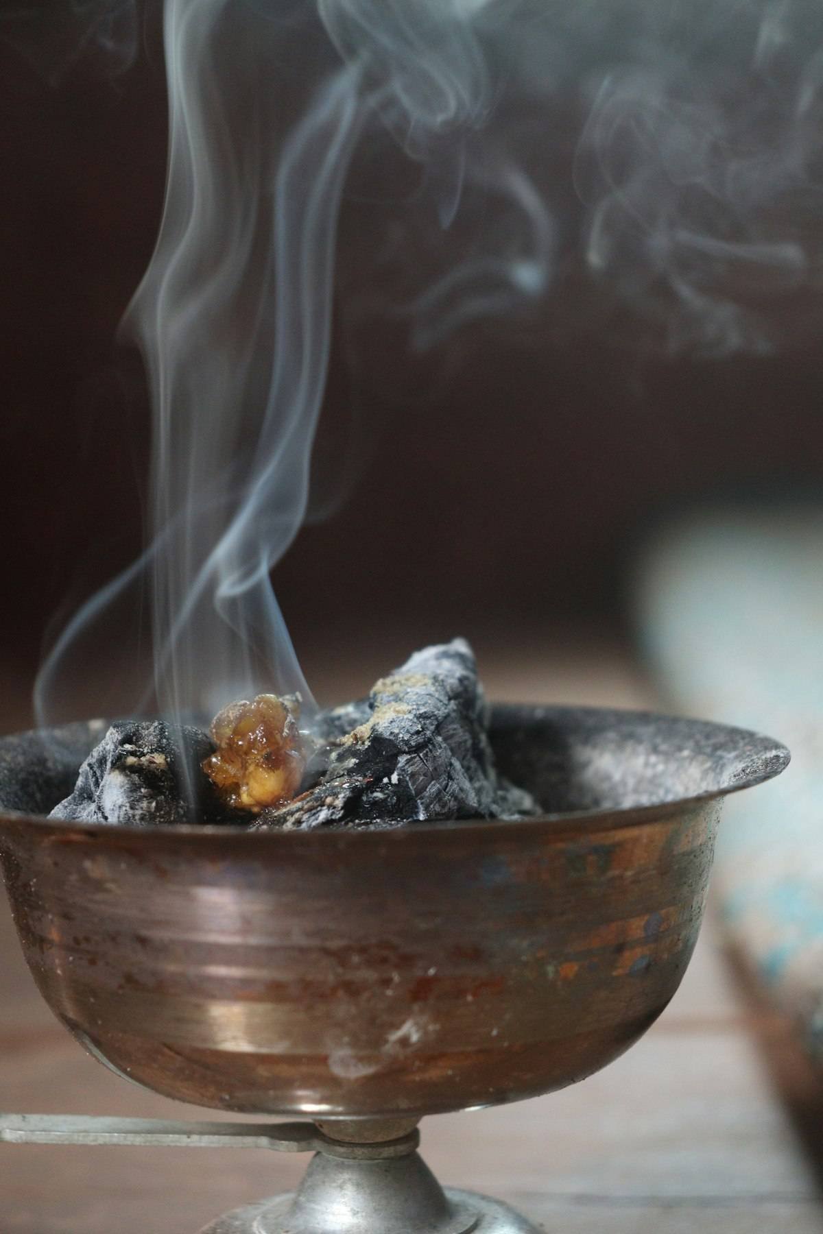 Myrrh spiritual meaning evoked by resin smoking on charcoal in a brass incense bowl